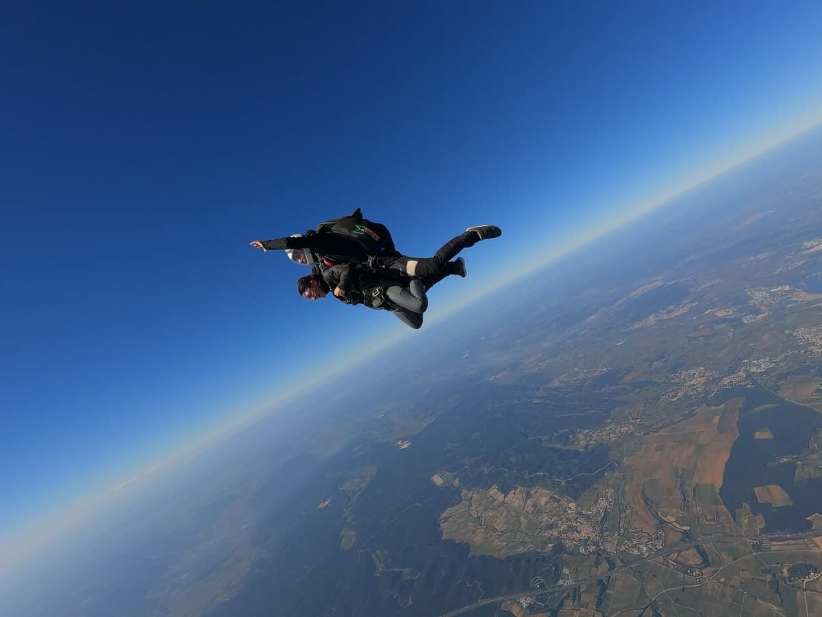Moniteur tandem rassurant un élève lors d'une chute libre — gestion du stress en parachutisme